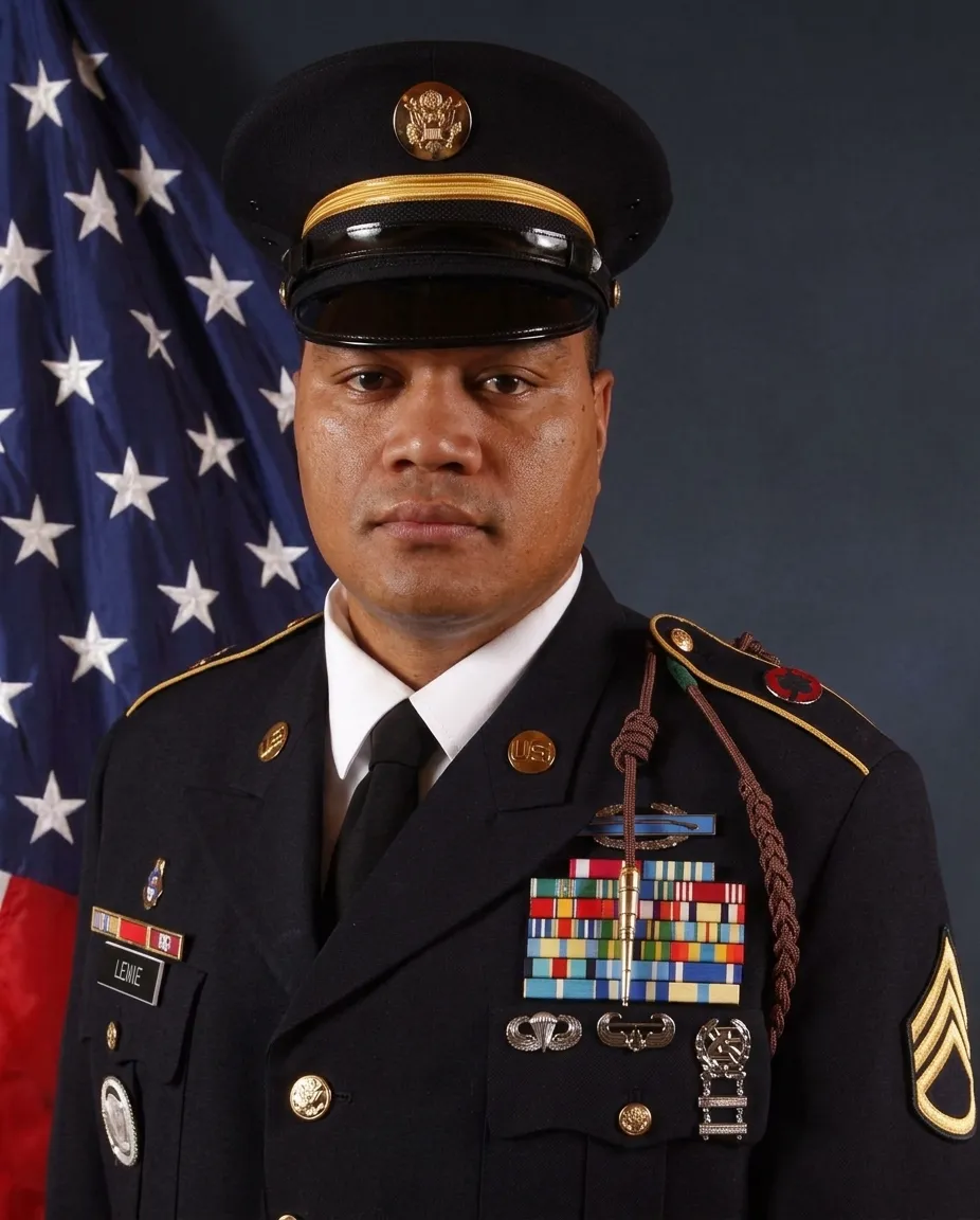 Enele Lefano in U.S. Army dress uniform in front of the American flag
